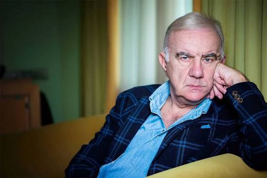 Gene Gnocchi seduto su un divano con aria pensierosa