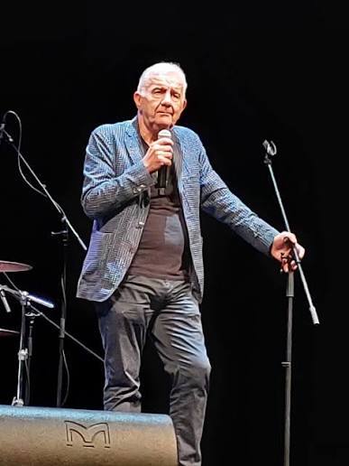 Gene Gnocchi in piedi sul palco con il microfono